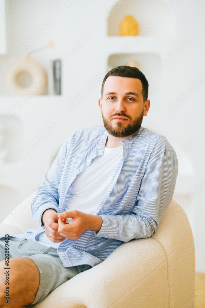 Portrait of attractive caucasian guy wearing stylish casual clotting sitting in armchair. Portrait of attractive caucasian guy wearing stylish casual clotting sitting in armchair.