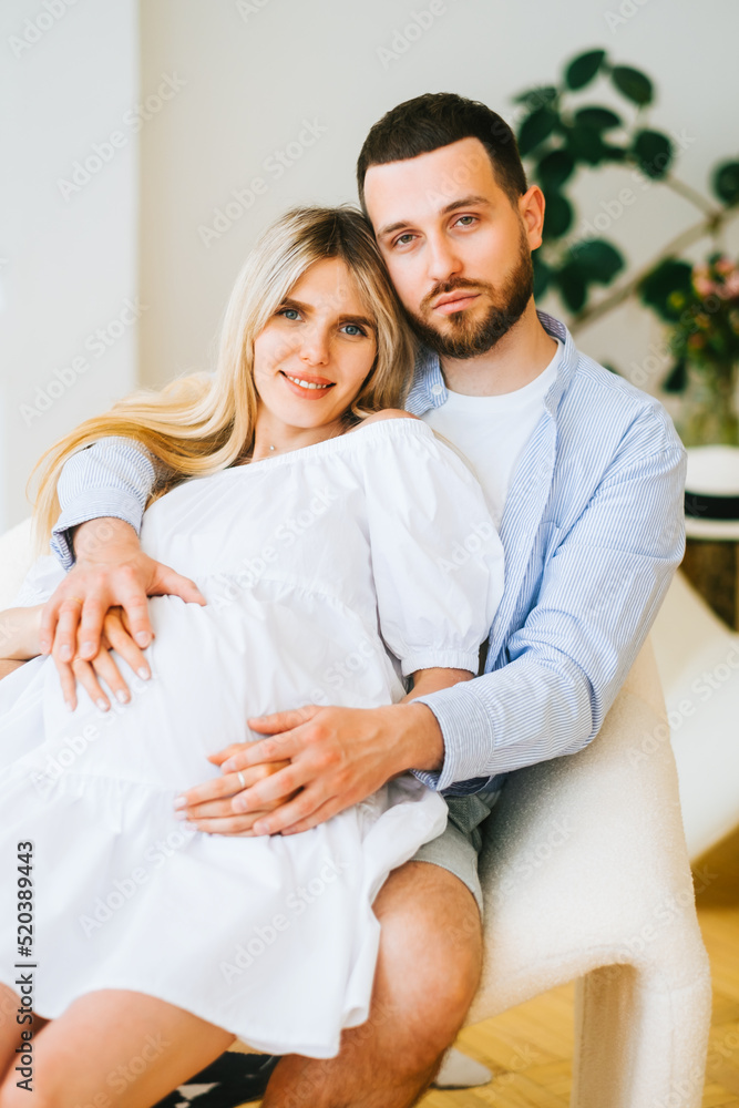 Portrait of future mother and father. Husband hugs pregnant wife. Happy family resting at home Portrait of future mother and father. Husband hugs pregnant wife. Happy family resting at home
