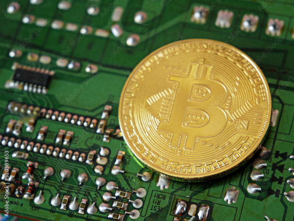 Bitcoin golden coin on computer circuit board, closeup Bitcoin golden coin on computer circuit board, closeup
