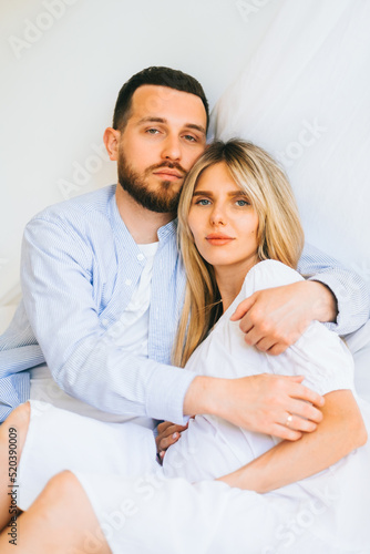 Portrait of future mother and father, husband hug pregnant wife. Happy family resting at home 