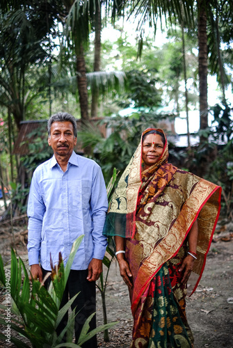 South asian village couple smiling portrait in outdoor environment, Bangladeshi rural people wearing traditional dress