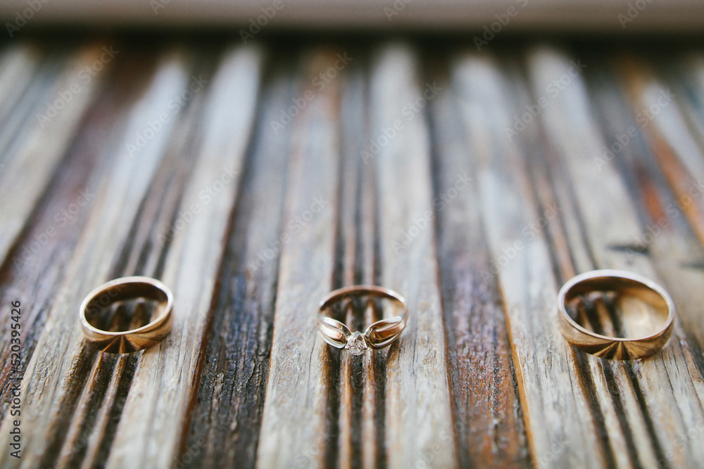 Three wedding rings on a wooden striped board Three wedding rings on a wooden striped board