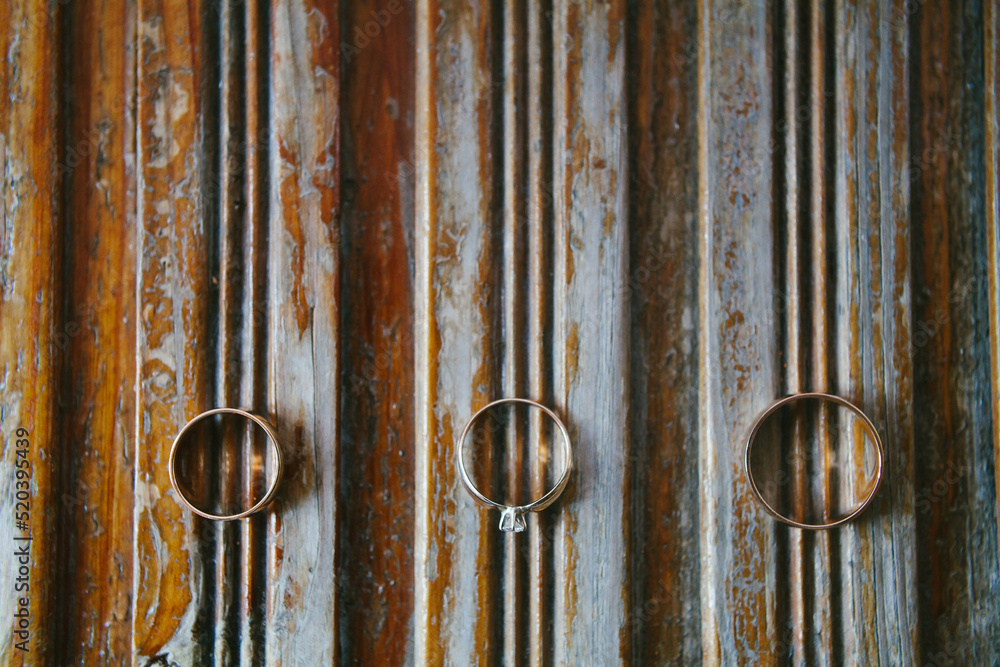 Three wedding rings on a wooden striped board Three wedding rings on a wooden striped board