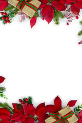 Christmas decoration. Frame of gift boxes, red poinsettia flowers, christmas tree branch, red berries on a white background with space for text. Top view, flat lay