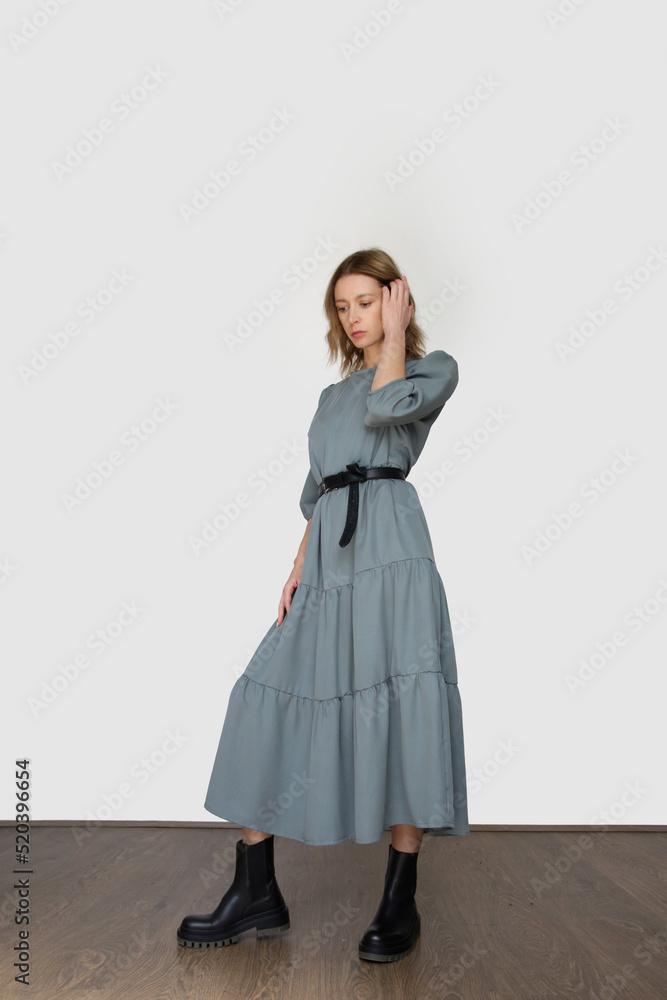 Serie of studio photos of young female model in casual gentle grey midi dress Serie of studio photos of young female model in casual gentle grey midi dress