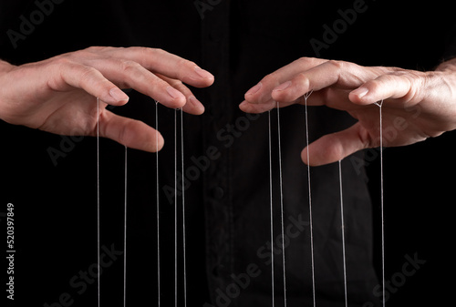 Фотография Hand manipulating and controlling smth with strings concept