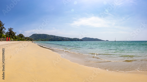Panorama of Patong beach with sand, sea, blue sky and sun flare, a popular tourist destination in Phuket, Southern of Thailand