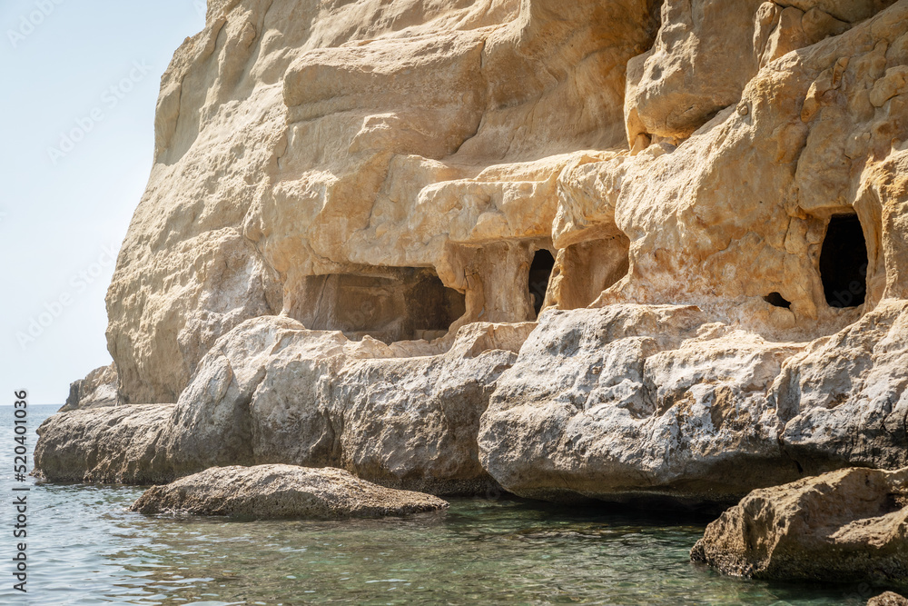 Carved caves in the rocks. Matala beach, Heraklion, Crete island, Greece. Travel vacation concept.