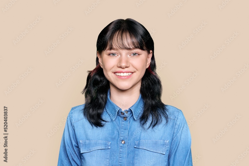 Joyful teenage girl looking at camera on brown background Joyful teenage girl looking at camera on brown background