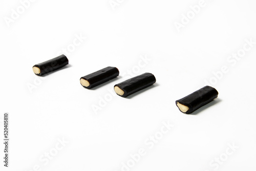 Black licorice candy with filling on white background