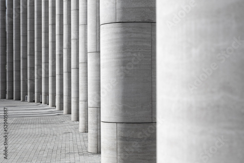 Series of partially illuminated columns made of modern materials standing in semicircle