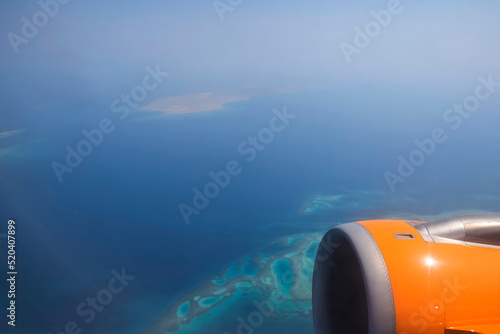 View from plane to sea landscape through the haze of clouds. Selective focus.