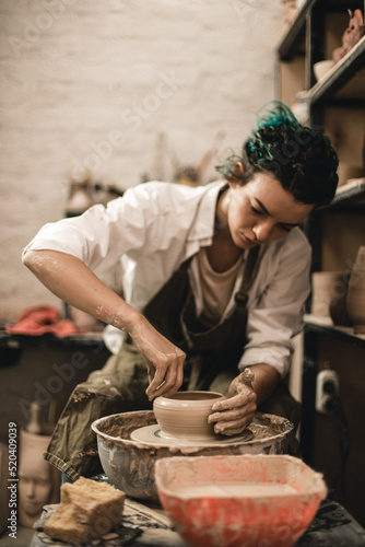 Young woman is working with clay