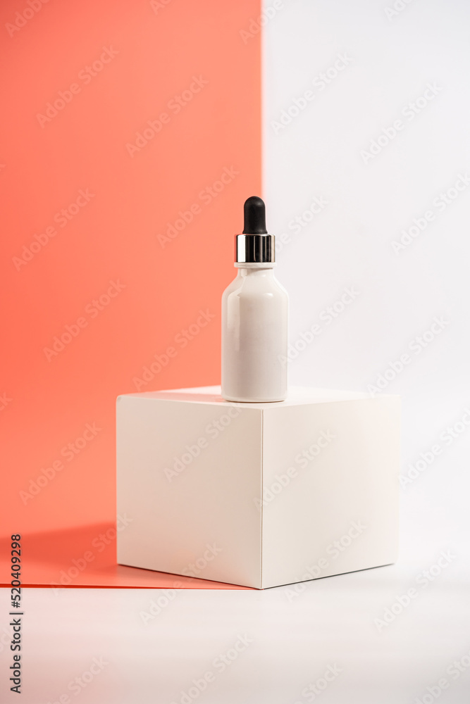 Serum or essential oil bottle on white and pink background. Bright shadows. Beauty product concept. Serum or essential oil bottle on white and pink background. Bright shadows. Beauty product concept.
