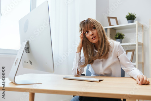 Pensive adorable blonde businesswoman worker recline on hand look aside thinking of problem solution in light modern office. Unhappy employee work on computer online making big mistake. Copy space