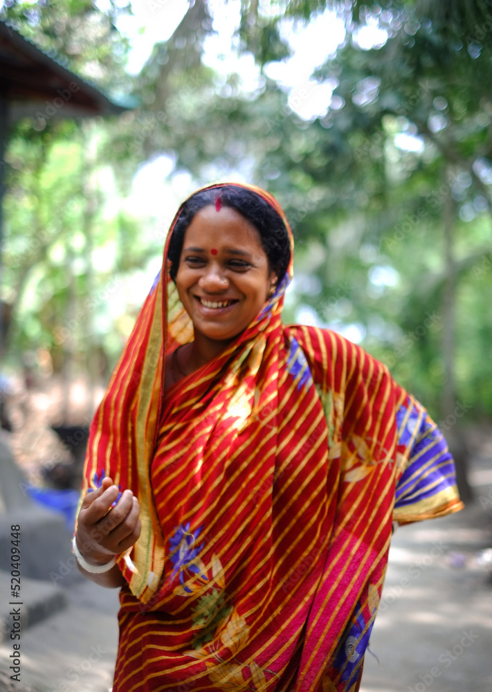 Bangladeshi hindu religious woman smiling in outdoor village environment wearing traditional dress Bangladeshi hindu religious woman smiling in outdoor village environment wearing traditional dress