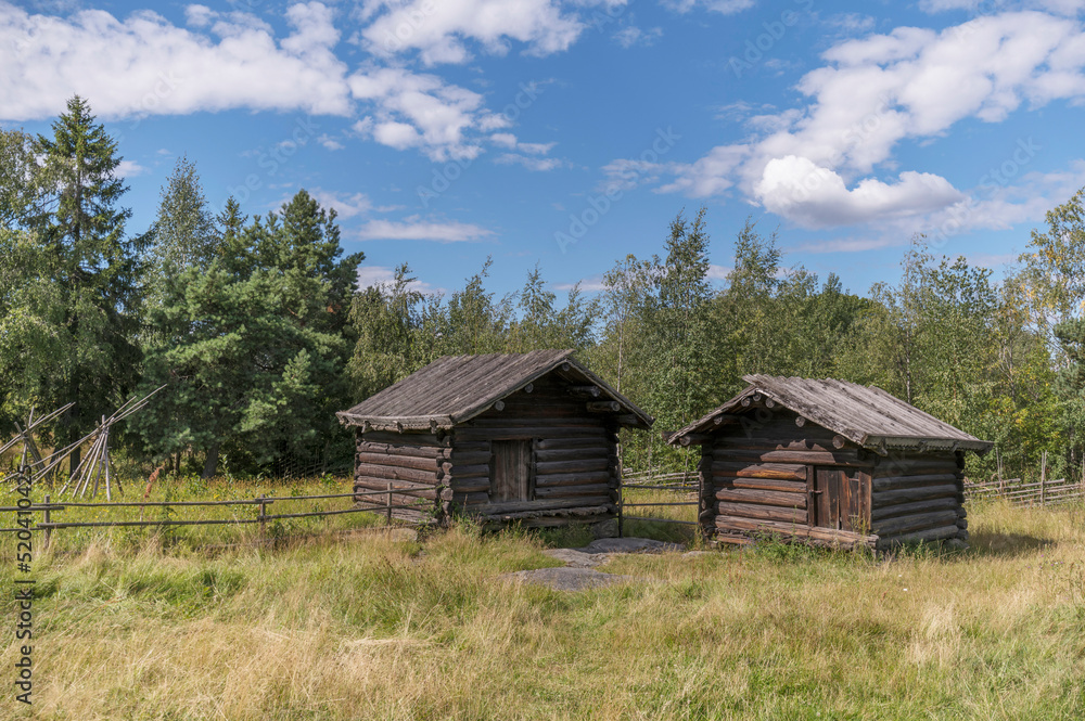 Old log sheds houses in a meadow, a sunny summer day in Stockholm