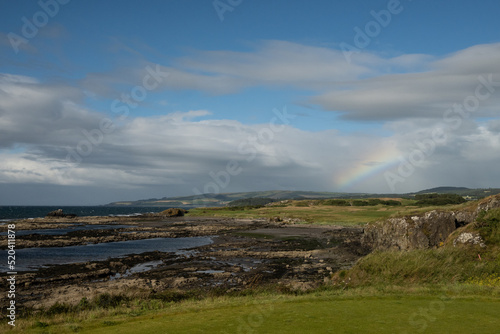 A rainbow sets on the rugged coastline of Ayrshire 
