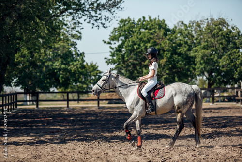 Teenage Girl in helmet Learning Horseback Riding. © sergiophoto