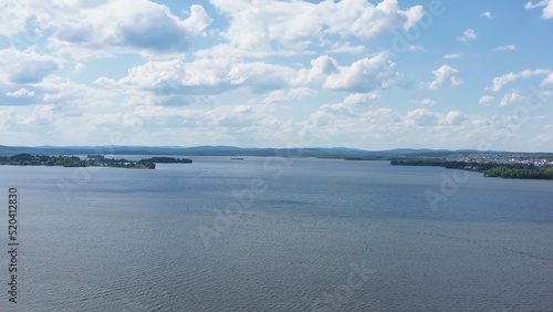 Top view of beautiful lake on background of horizon with sky. Video. Panorama of clear lake and green shores with beautiful horizon of blue sky