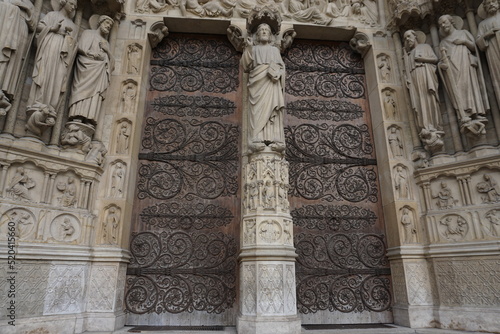 detail of the facade of the cathedral notre dame in downtown paris france with two wooden old doors