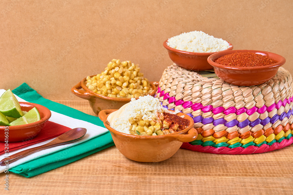 Esquites (traditional Mexican food) in a clay dish dressed with