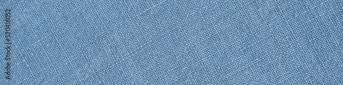 Light blue woven surface close-up. Linen textile net texture. Fabric handicraft banner. Textured braided natural header. Macro