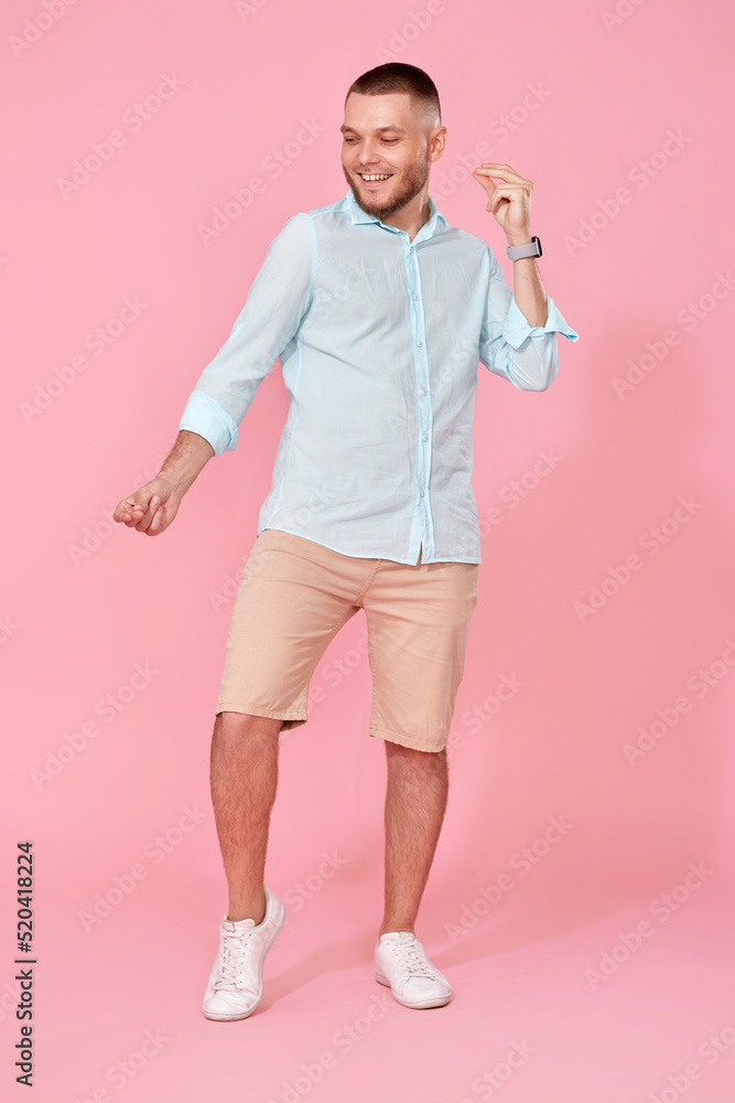 cheerful young happy man dance on pink background. cheerful young happy man dance on pink background.