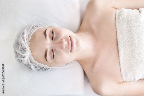 Woman in moisturizing anti-wrinkle mask. A woman is lying down  resting in a beauty salon. SPA procedures at home or in a cosmetology center