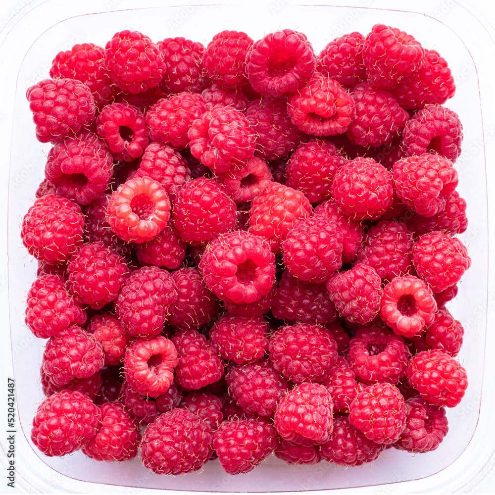 Red raspberries in a transparent plastic container, top view Red raspberries in a transparent plastic container, top view