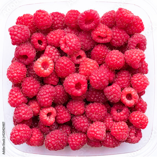 Red raspberries in a transparent plastic container  top view