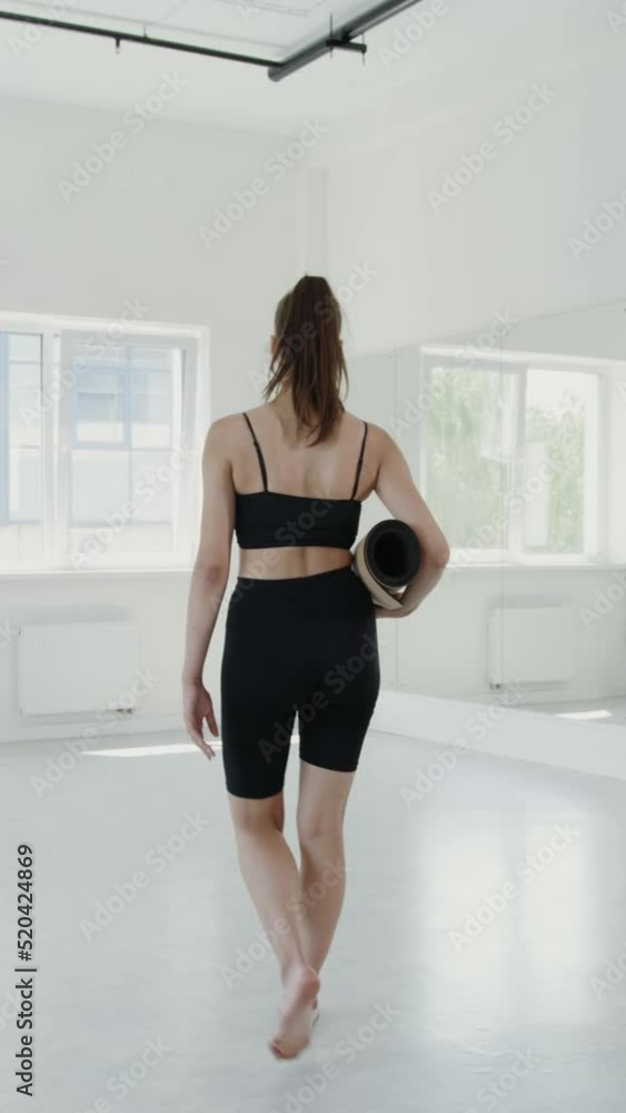 European girl in sportswear comes to gymnastics hall and starts a warm-up European girl in sportswear comes to gymnastics hall and starts a warm-up