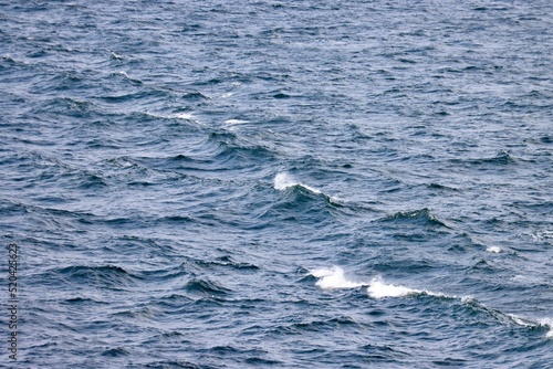 Waves far in open Baltic sea. Deep blue water  white foam on top of waves. Photo taken from ship