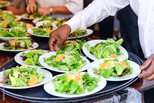 Serving Up Freshness: Waiter Holding a Tray of Delicious Salad Plates