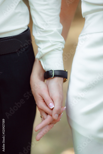 Newlyweds hold hands. Husband and wife hold each other at the wedding ceremony. The concept of a strong family. The concept of a marriage contract.