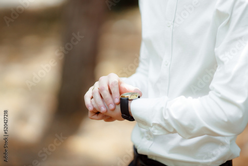 The man looks at his watch. I m not late. A businessman watches the time on a mechanical watch. Business and business lifestyle concept. The man is waiting for something.