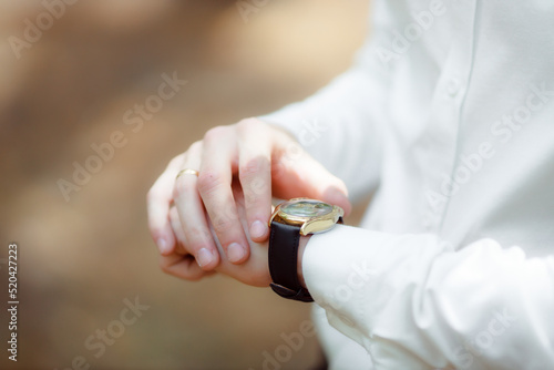 The man looks at his watch. I'm not late. A businessman watches the time on a mechanical watch. Business and business lifestyle concept. The man is waiting for something.