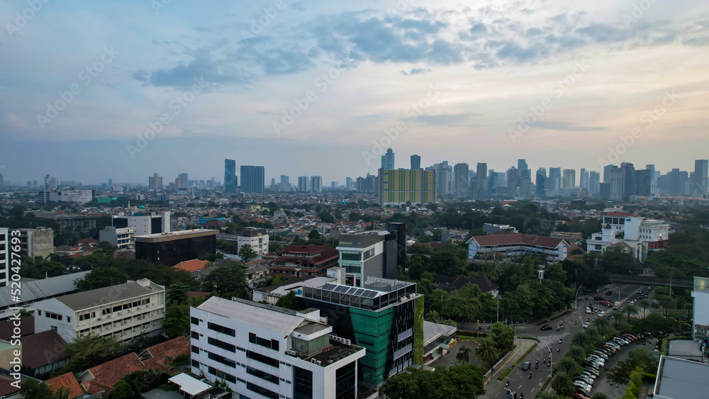 Obraz premium Aerial view of office buildings in Jakarta central business district and noise cloud when sunset. 