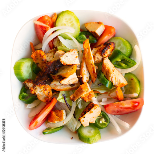 Delicious healthy salad with grilled chicken fillet, cucumber, green padron pepper, tomatoes and onion. Isolated on white background
