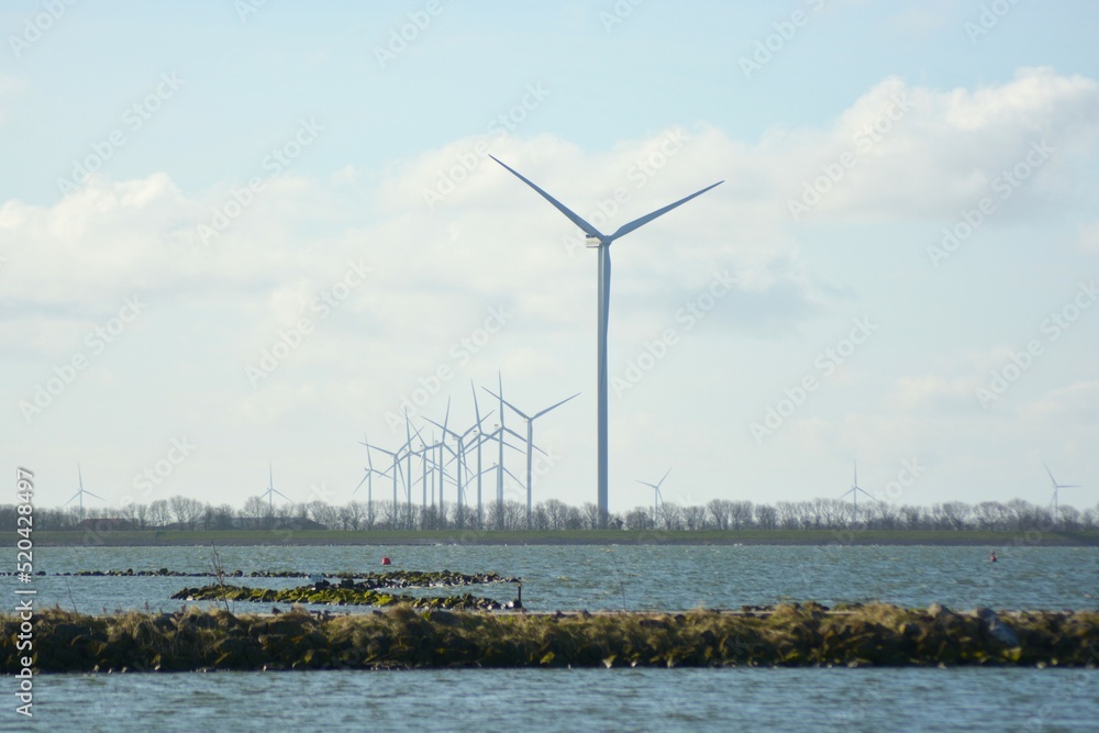 Offshore wind turbines at Amstelmeer, Netherlands. 
 Dutch windmill park in the North sea. Space for text. 