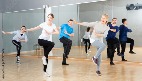 Fototapeta Naklejka Na Ścianę i Meble -  Cheerful people practicing vigorous lindy hop movements in dance class..