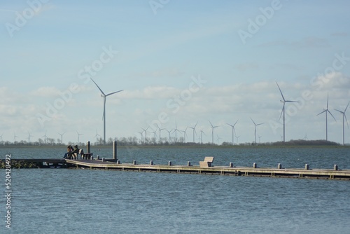 Offshore wind turbines at Amstelmeer, Netherlands.   Dutch windmill park in the North sea. Space for text.  © Lara Red