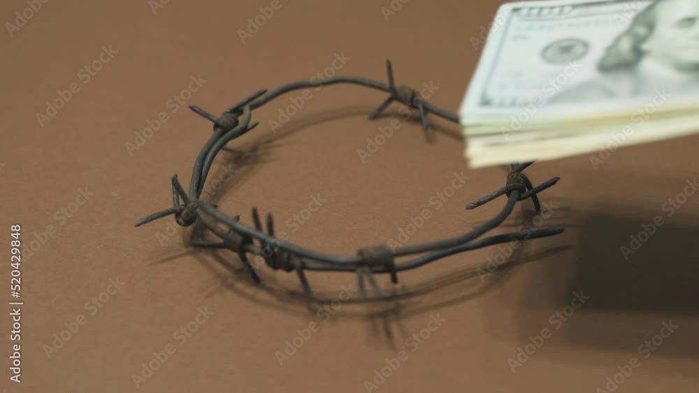 Dollars are placed in a circle of barbed wire. Symbol of corruption, bribery. Law and crime. Dollars are placed in a circle of barbed wire. Symbol of corruption, bribery. Law and crime.
