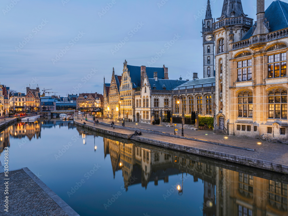 Historic medieval building at dusk on Leie river in Ghent, Belgium
