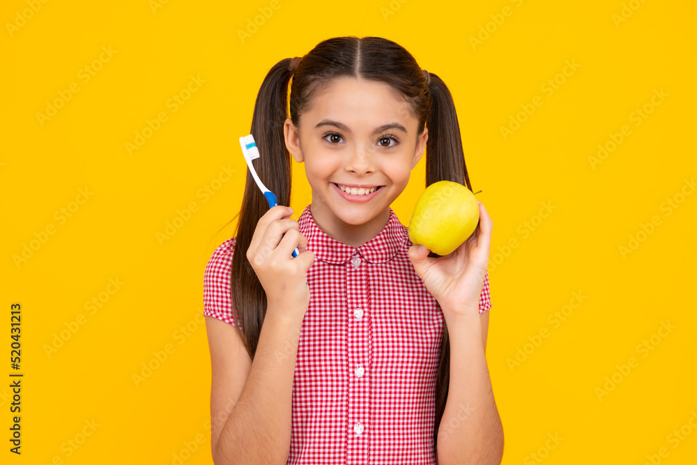 Teen girl brush her teeth, dental healthy concept, isolated over yellow background. Healthy kids teeth. Apple vitamins for healthy teeth. Teen girl brush her teeth, dental healthy concept, isolated over yellow background. Healthy kids teeth. Apple vitamins for healthy teeth.