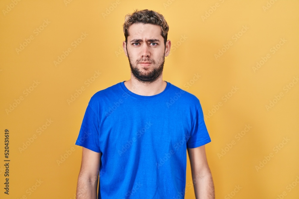 Hispanic man with beard standing over yellow background skeptic and nervous, frowning upset because of problem. negative person. Hispanic man with beard standing over yellow background skeptic and nervous, frowning upset because of problem. negative person.