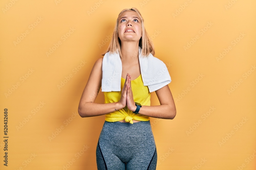 Beautiful blonde sports woman wearing workout outfit begging and praying with hands together with hope expression on face very emotional and worried. begging. Beautiful blonde sports woman wearing workout outfit begging and praying with hands together with hope expression on face very emotional and worried. begging.