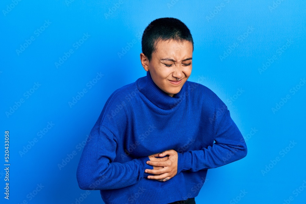 Beautiful hispanic woman with short hair wearing turtleneck sweater with hand on stomach because nausea, painful disease feeling unwell. ache concept. Beautiful hispanic woman with short hair wearing turtleneck sweater with hand on stomach because nausea, painful disease feeling unwell. ache concept.