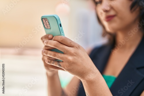 Young beautiful hispanic woman smiling confident using smartphone at street