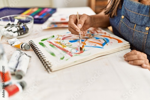 Young hispanic artist woman smiling happy drawing at art studio.